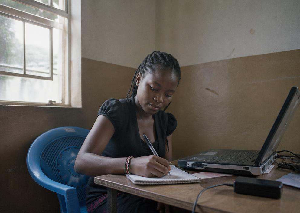 A Kenyan entrepreneur learning on a laptop in a bright modern workspace